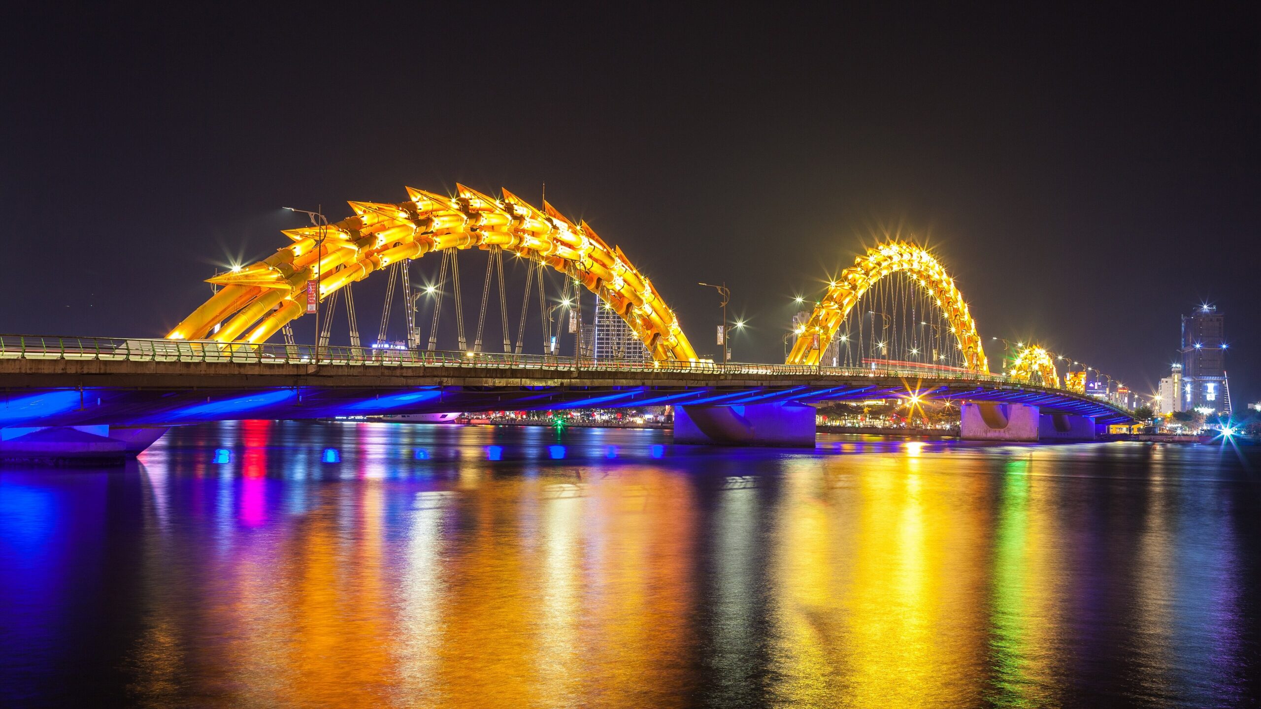 Da Nang to Phong Nha: Road Route, Timing and Private Transfer Prices Dragon Bridge lit up at night over the Han River in Da Nang